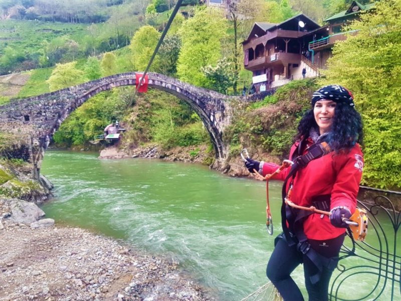 FIRTINA DERESİ'NDE ZIPLINE YAPMADAN DÖNÜLÜR MÜ? - Yapmayı planladığımız pek çok şey hava muhalefetinden yapılamıyor. Bunların içinde Fırtına Deresi’nde rafting yapmak da var. Sular çok yüksek rafting için ama buralara kadar gelmişken Fırtına Deresi üstünde zipline yapmadan dönemem. Yemek yediğimiz restoranda ki Dilek hanımın önerisiyle Osmanlı Rafting’in yolunu tutuyoruz. En uzun parkur buradaymış ve tarihi köprülerden birinin altından geçiyormuş. Bunu duymak bile beni çok heyecanladırıyor.
