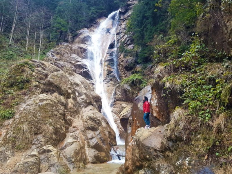 CİMİL ŞELALESİ VE CİMİL YAYLASI YOLUNDA - Otelden çıktığımız gibi Cimil Yaylası yoluna düşüyoruz. Yolda bize yine dere, karlı dağlar, hafif güneşli buz gibi bir hava ve şelaleler eşlik ediyor. Yol bir hayli bozuk. Otelden çıktıktan çok kısa bir süre sonra kocaman bir şelaleyle karşılaşıyoruz. Bir adı yok. Yoldan görülebiliyor.Şelaleden ayrıldıktan sonra bir müddet toprak yollardan gidiyoruz. Yol bizi bir köprüden geçiriyor ve yol ikiye ayrılıyor. Ne tabela var ne de internet çalışıyor. Ne taraftan gideceğimizi bilemiyoruz. Şansa sağa dönüyoruz. Doğru yola girmişiz. Toprak yollar bir müddet sonra beton oluyor. Bölgede kış zor geçtiğinden yolları betondan yapıyorlarmış. Az gittik uz gittik Cimil Şelalesi’ne ulaştık.