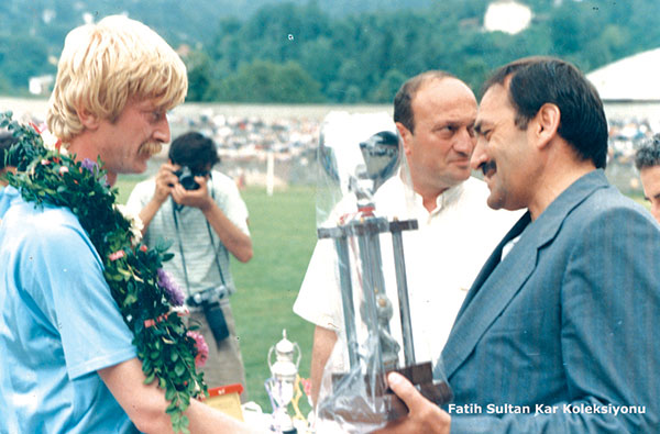 Futbolculuk hayatında bir çok başarıya imza atan Hüsnü Kürkçü bir maç öncesi dönemin Rize Valisi Ömer Büyükkent tarafından kutlanırken. Arkada dönemin Gençlik ve Spor İl Müdürü Ömer Akmehmet gözükmektedir.