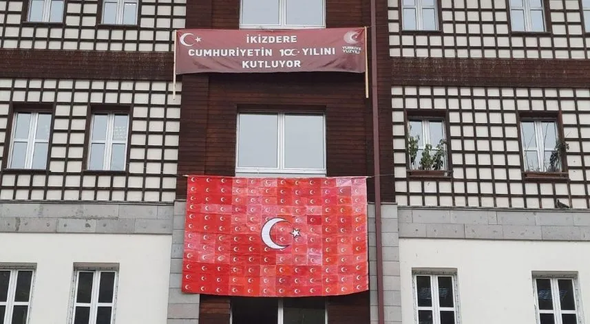 Öğrencilerin ellerinde çıkan bayraklar kaymakamlık binasına asıldı