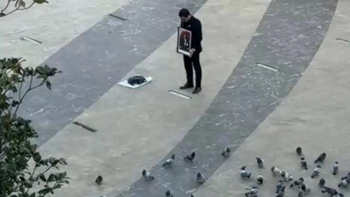 Elinde Atatürk tablosu ile saygı duruşunda bulundu